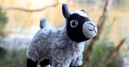 A grey and black plush goat 